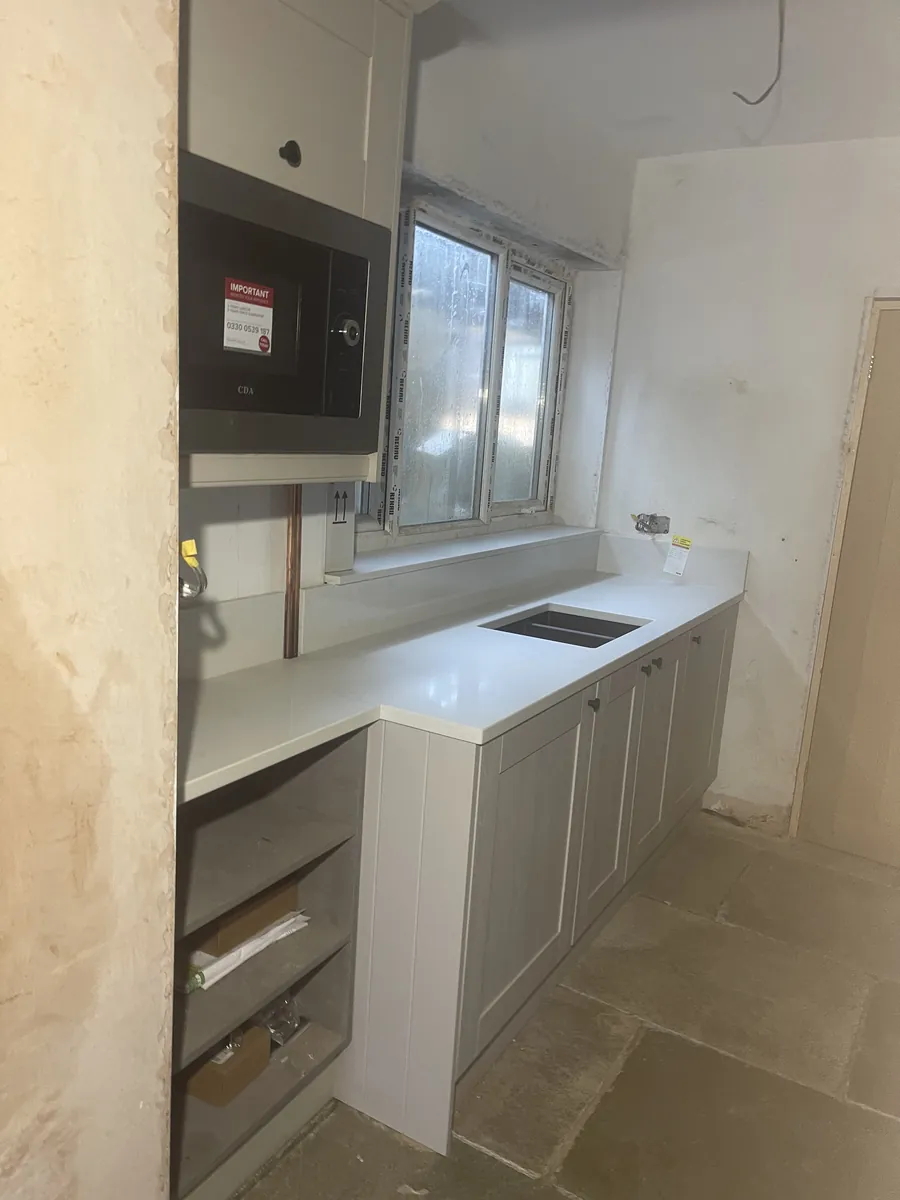 Quartz worktop and undermount sink cut-out being fitted during a kitchen renovation