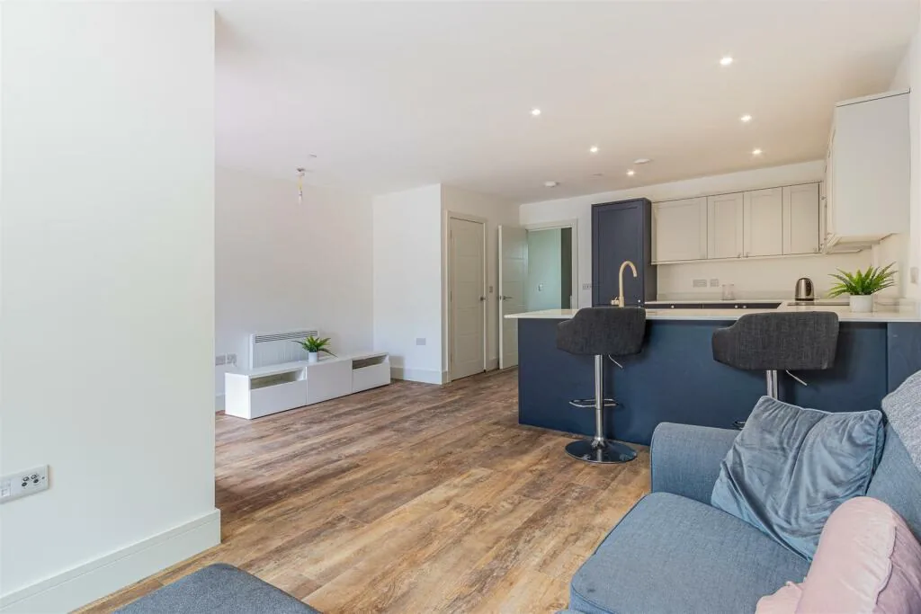 Open-plan kitchen and living space with a navy island and brass tap