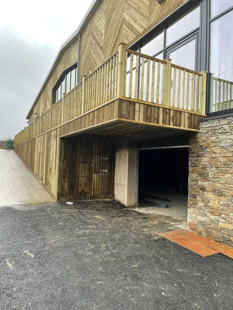 Raised timber balcony with a spindle balustrade and chevron timber cladding on a commercial building